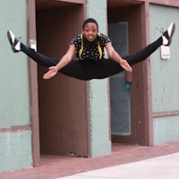 a young woman is jumping in the air in front of a building
