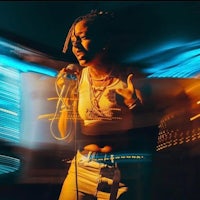 a woman singing into a microphone at night