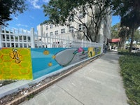 a colorful mural painted on the side of a fence