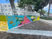 a colorful mural painted on the side of a fence