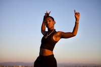 a young woman is posing with her hands in the air