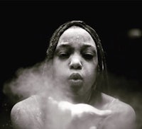 a black and white photo of a woman with dreadlocks