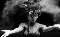 a black and white photo of a woman with dreadlocks